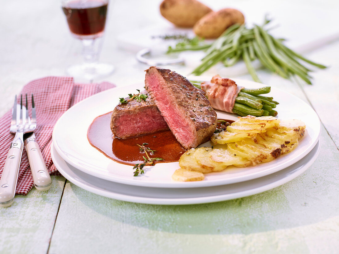 Beef fillet with bacon-wrapped beans and potato gratin