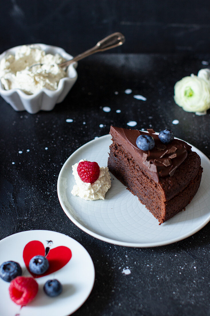 A slice of chocolate cake with ganache and fresh berries