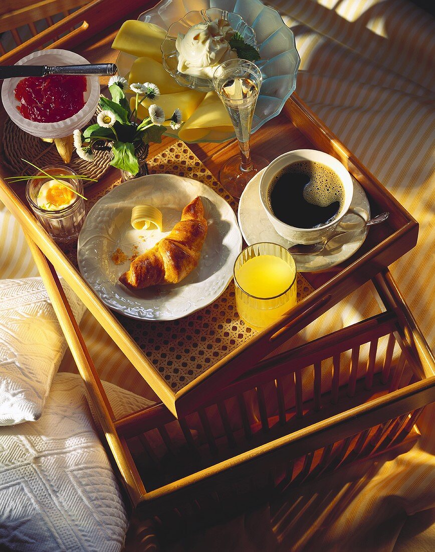 Frühstückstablett mit Croissant, Kaffee, Saft, Marmelade etc.