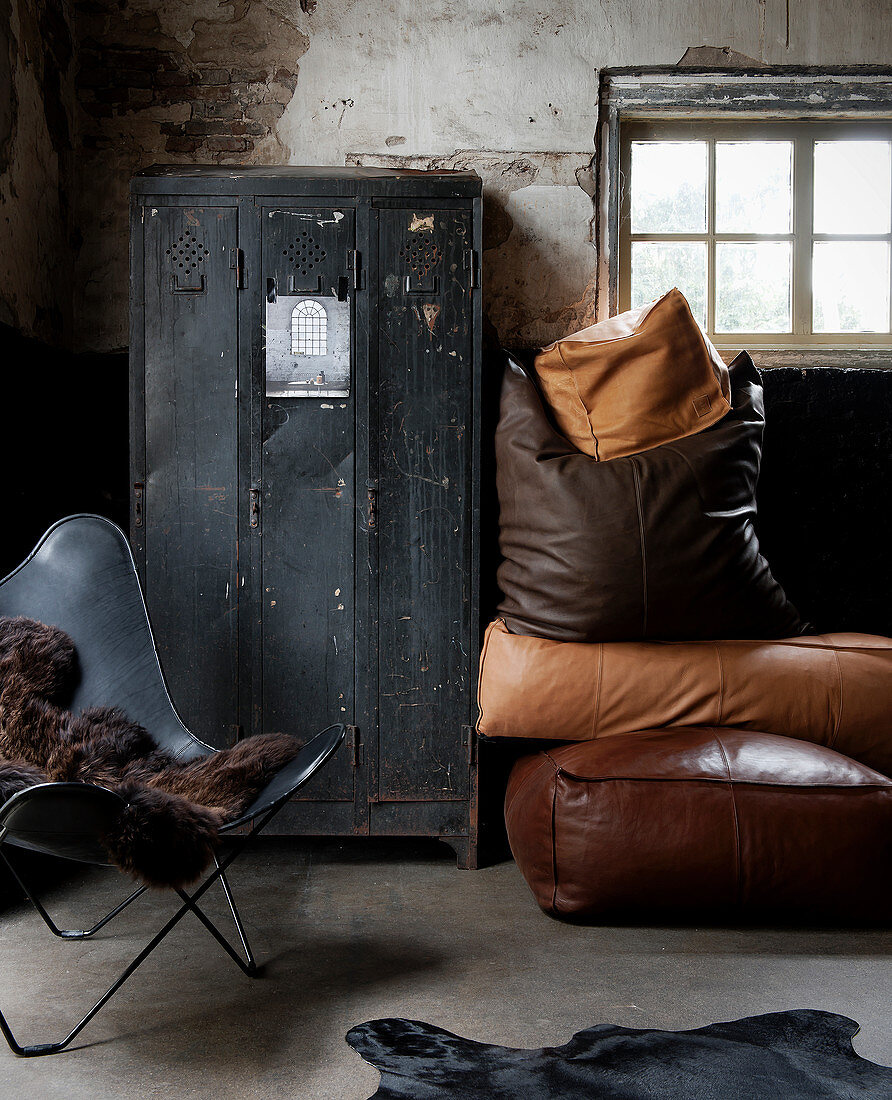 Industrial-style furnishings: black locker, leather cushions and classic Butterfly Chair