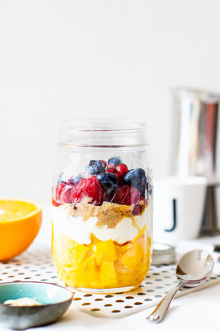 A layered dessert with fruit in a jar