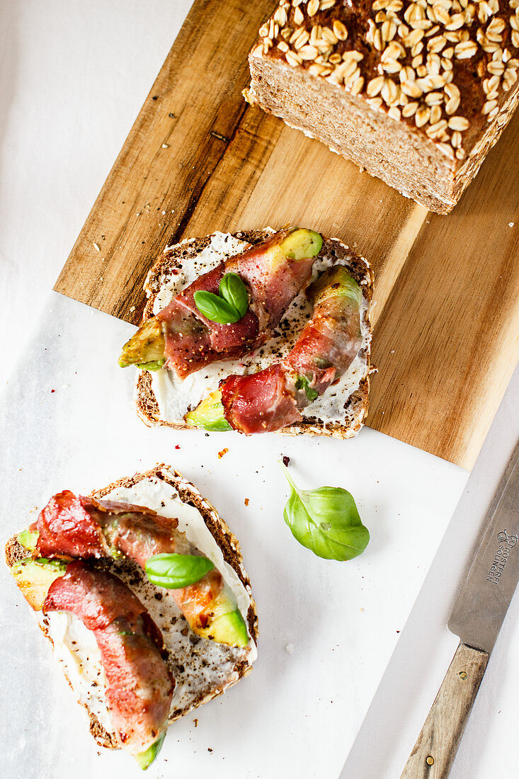 Bread topped with avocado and bacon