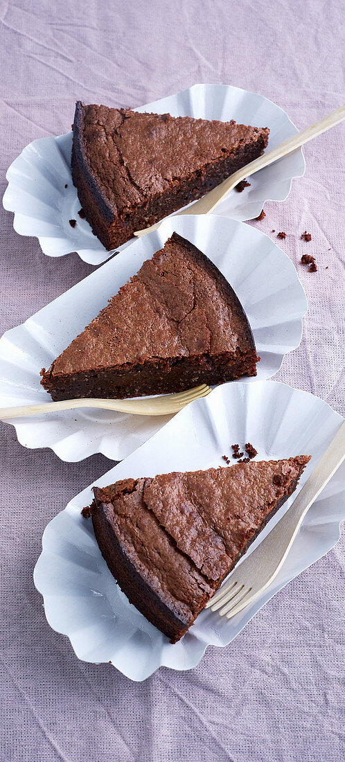 Sliced chocolate cake with amarettini in cardboard bowls