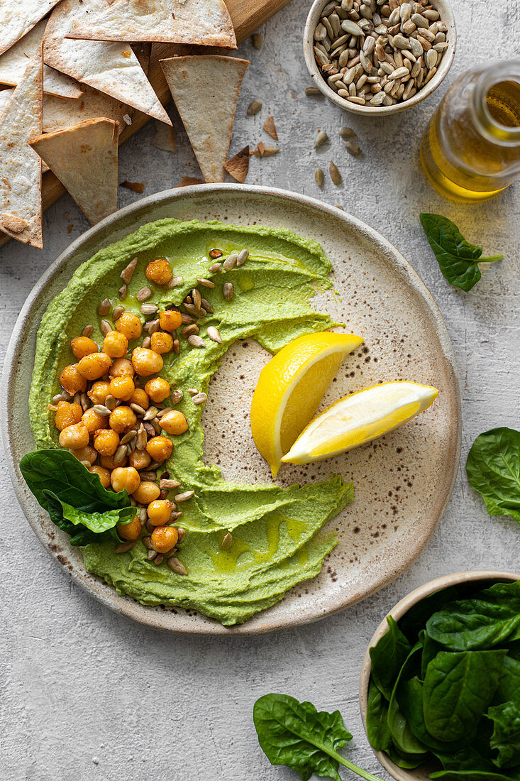Hummus with spinach, baked chickpeas, sunflower seeds and lemon