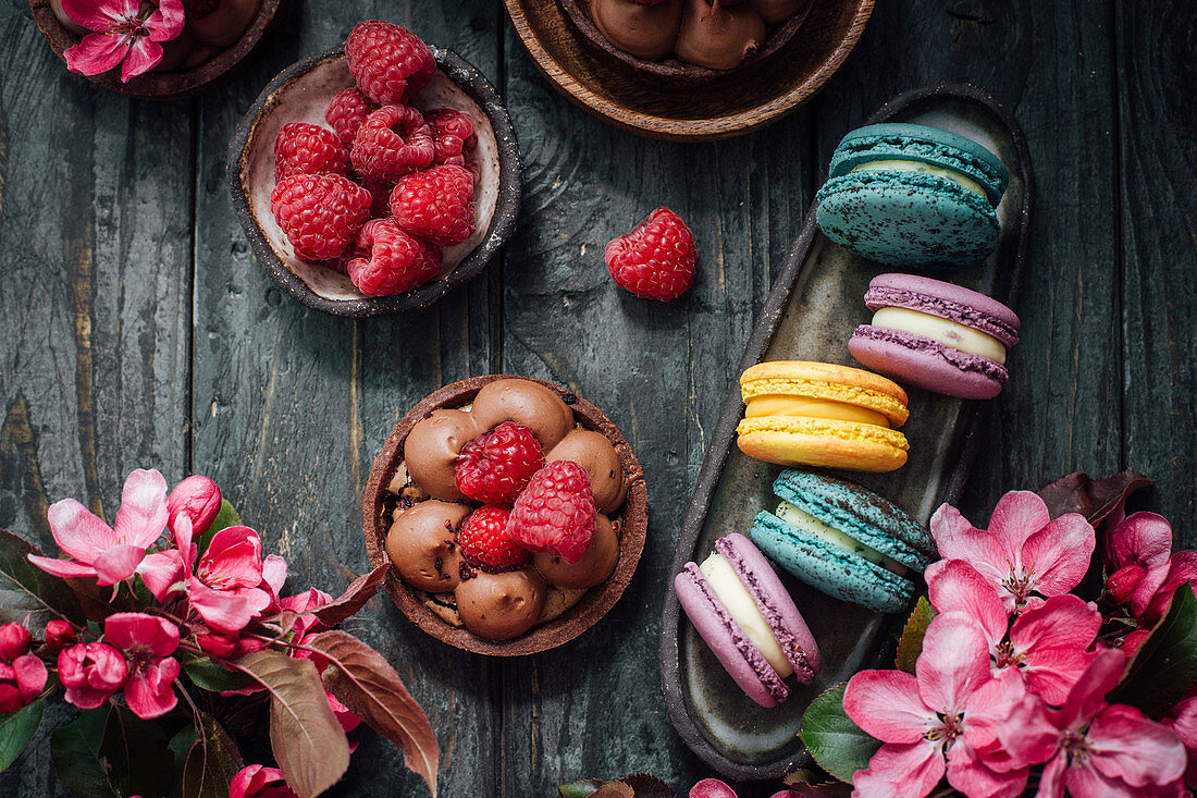 Bunte Macarons und Schokoladentörtchen mit Himbeeren