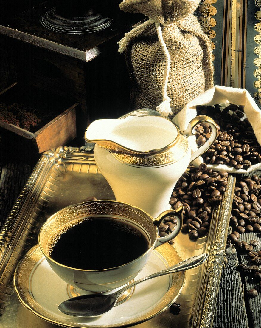 Tasse Kaffee & Kaffeesahne auf Tablett; Kaffeebohnen