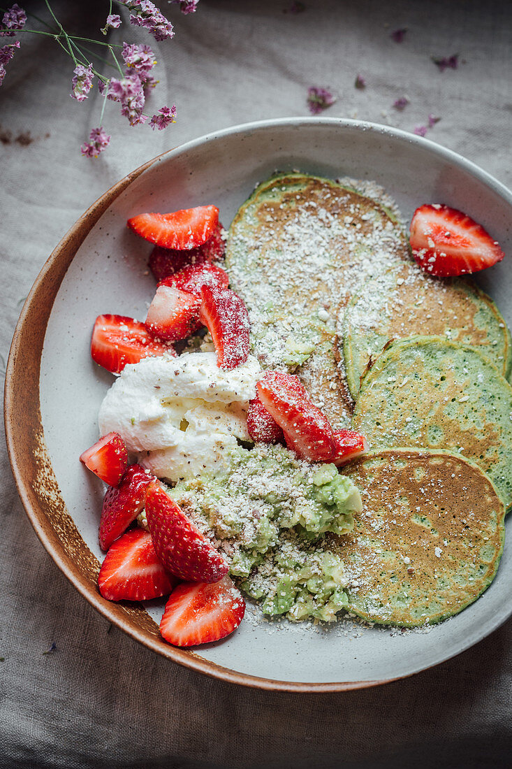 Pancakes with avocado, yoghurt and strawberries