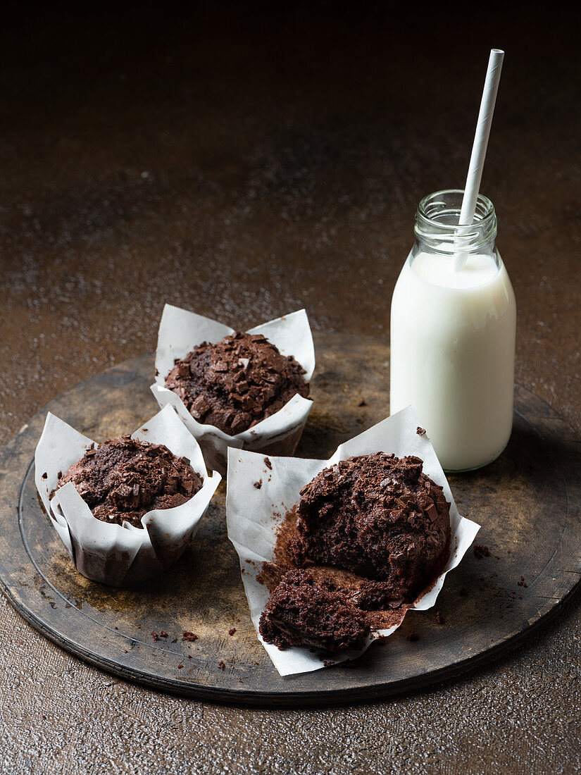 Chocolate muffins with milk on brown background