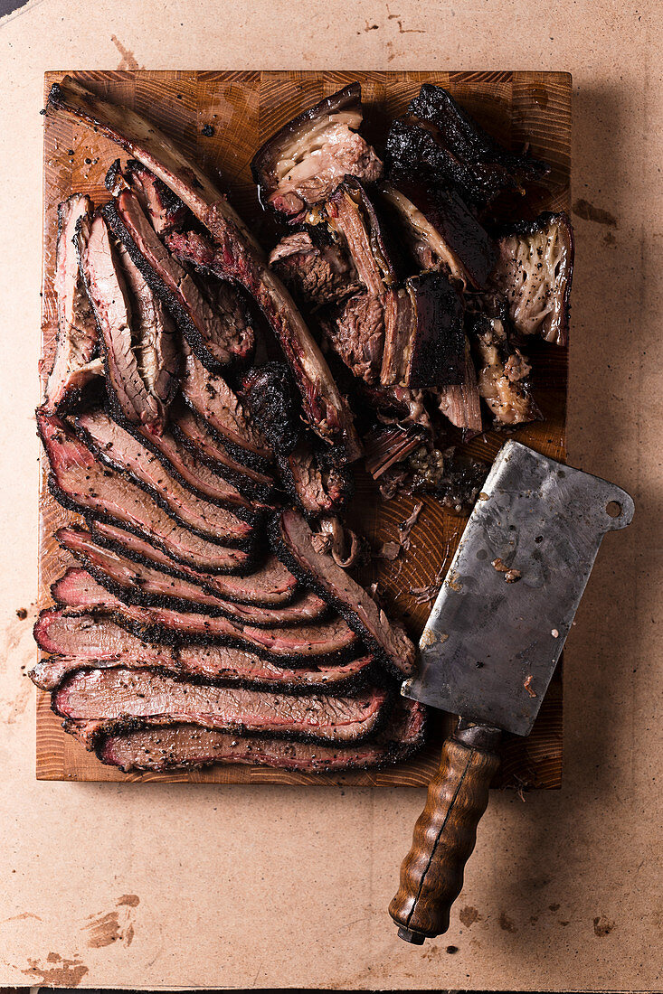 Beef Brisket und Rippen mit altem Hackbeil auf Holzbrett