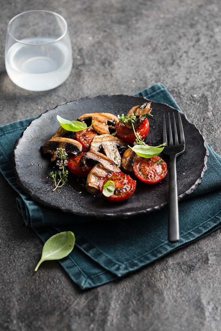 Grilled mushroom and tomato salad with glass of lemonade