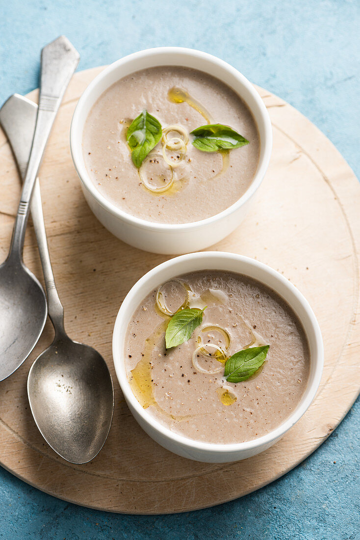 Zwei Pilzsuppen mit Zwiebelringen