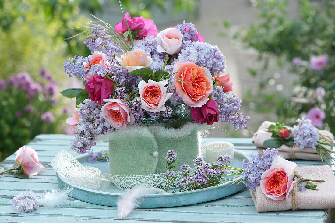 Bouquet of roses and lilacs in a felt coat as a table decoration