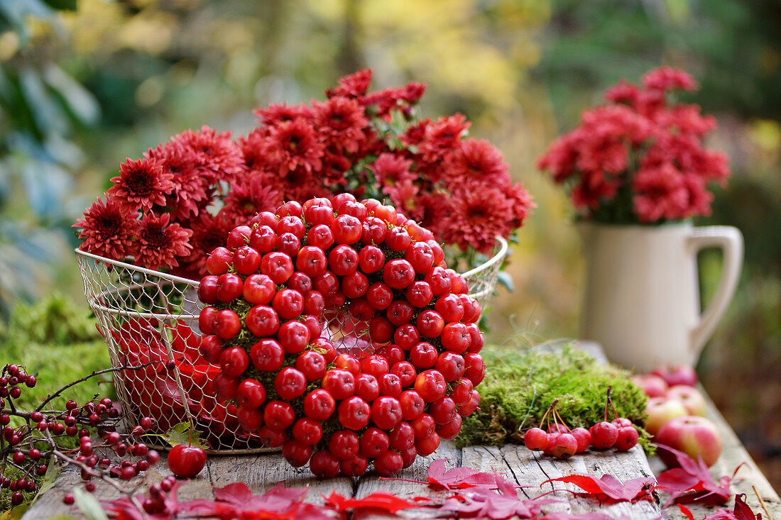 Kranz aus Zieräpfeln und Korb mit Chrysanthemen