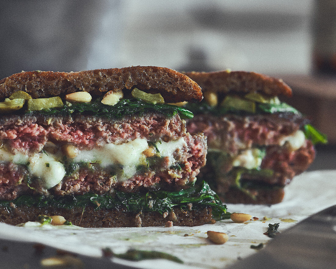 Burger with minced meat, mozzarella, spinach and pine nuts