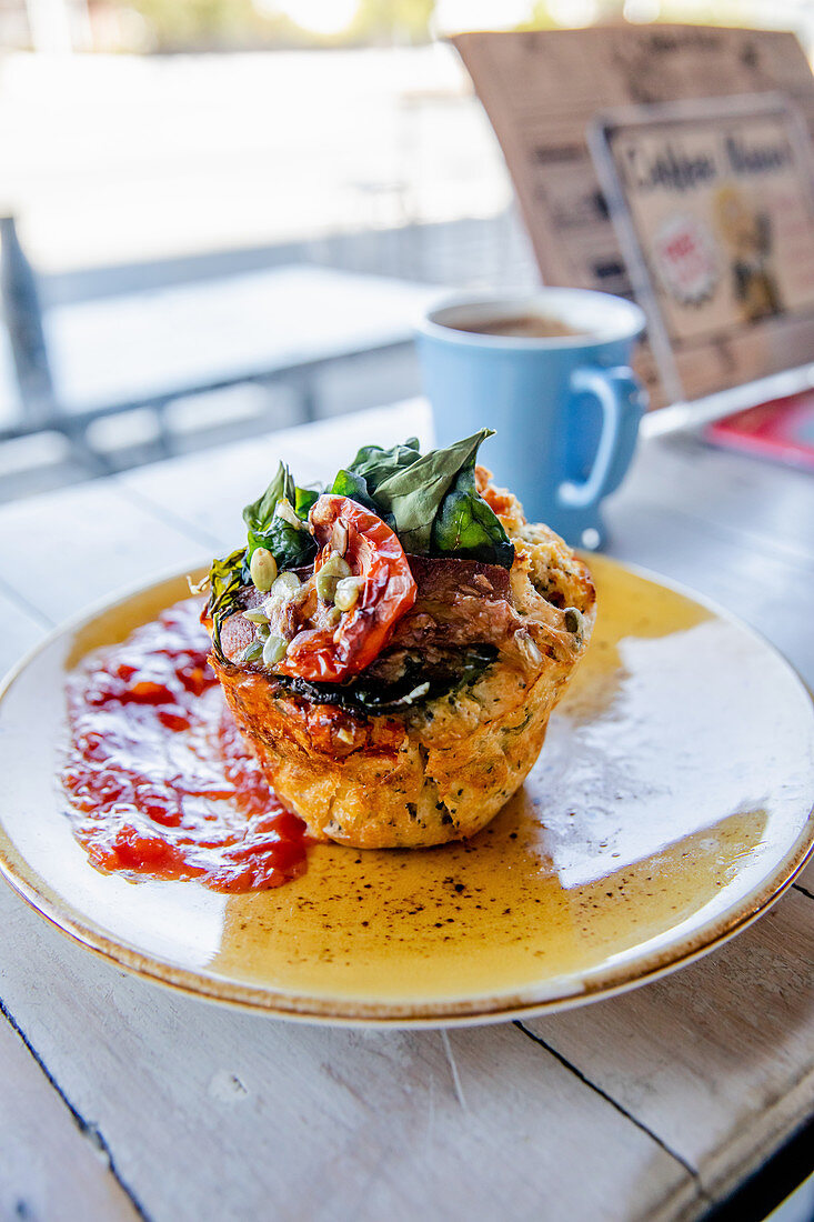 Pikanter Muffin mit Bacon und Spinat auf Restauranttisch