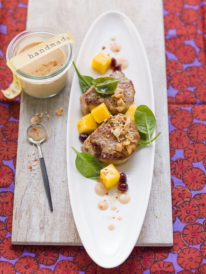 Pork fillet with peanut sauce and spinach and mango salad