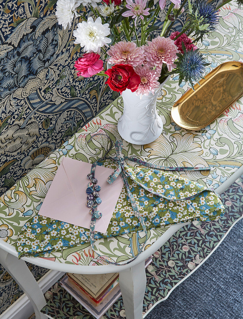 Top of console table covered with floral wallpaper