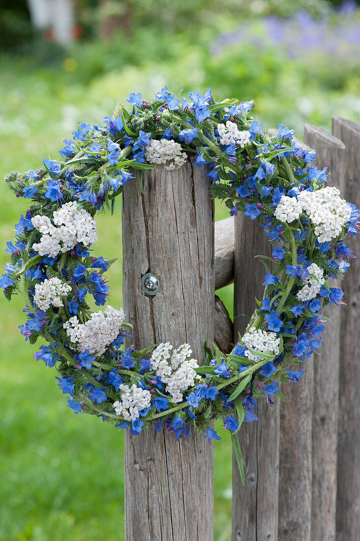 Blue and white wreath of blueweed and yarrow on the fence