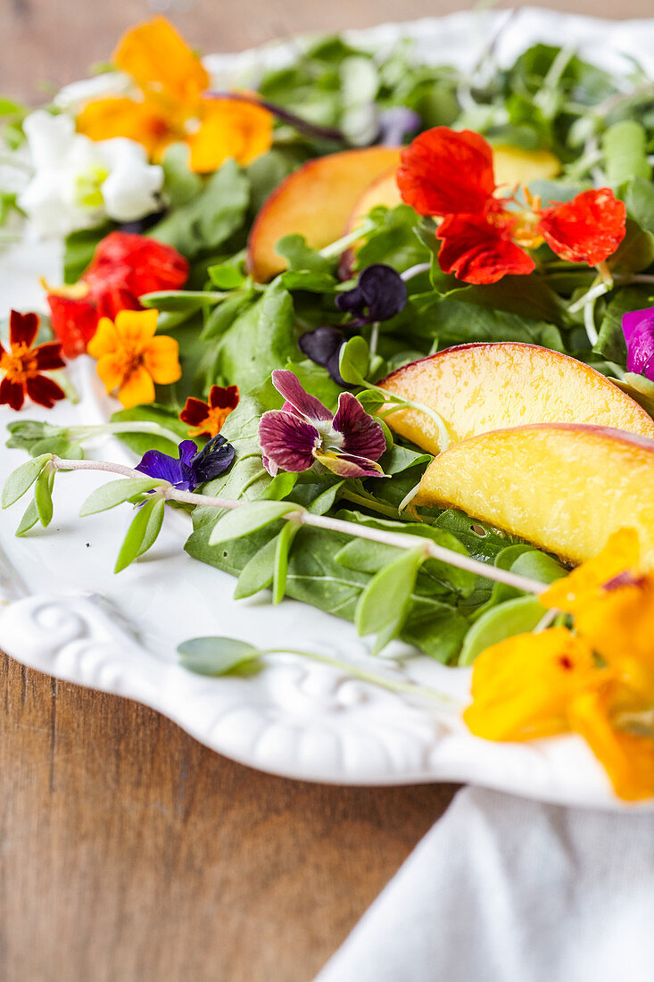 Edible flower-salad with arugula, microgreens and peaches