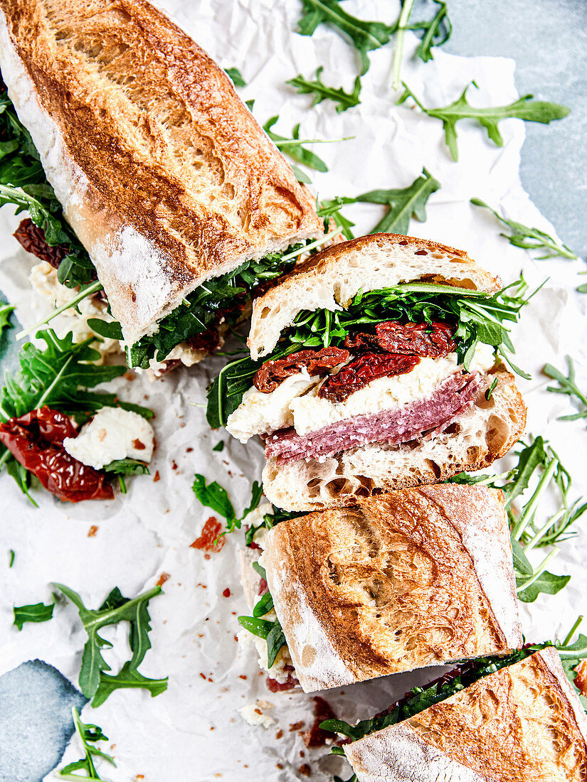 Baguette with salami, mozzarella, dried tomatoes and arugula