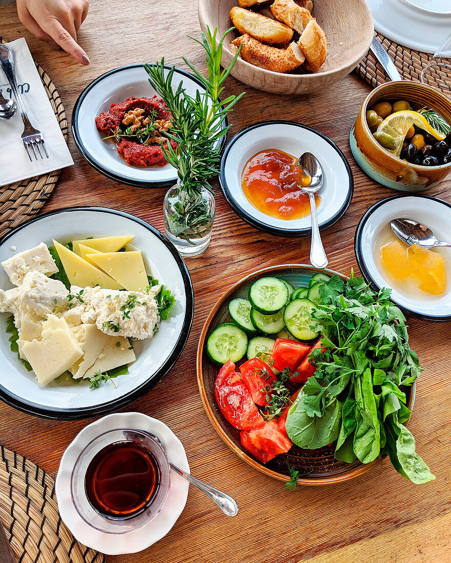 Verschiedene Vorspeisen (Käse, Brot, Oliven, Salat) auf Holztisch