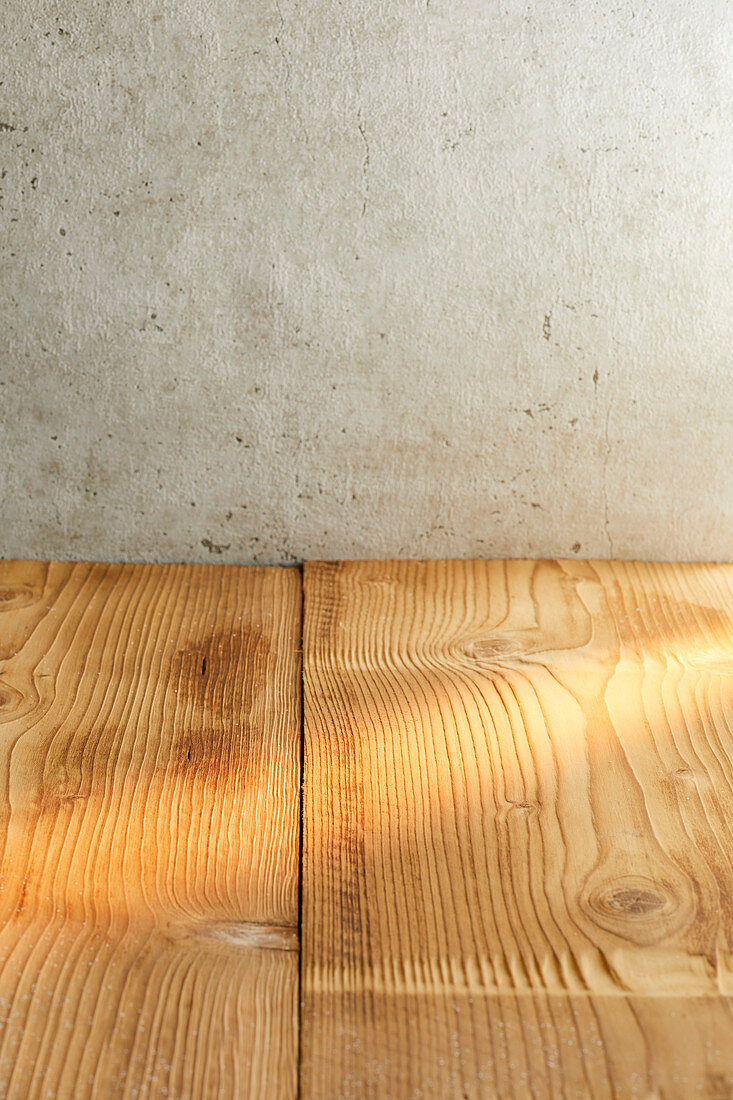 Wooden table in front of a concrete wall