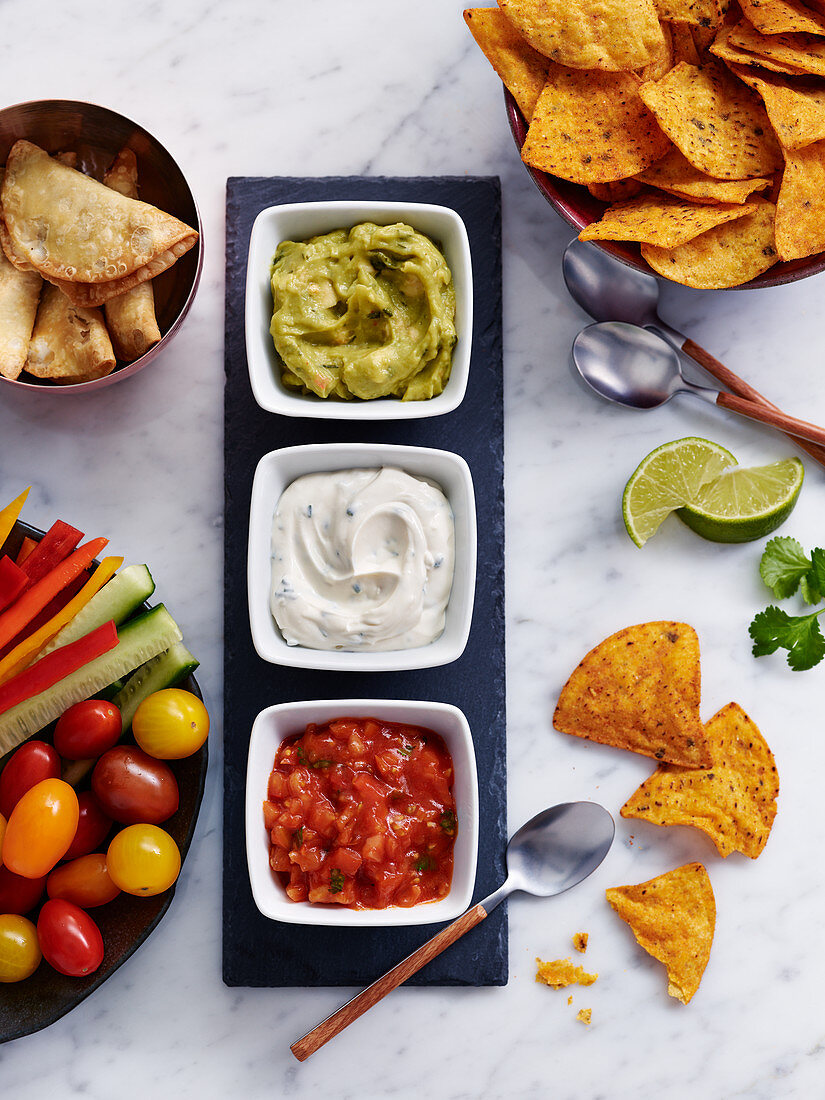 Guacamole, herb curd and salsa with nachos and vegetable sticks