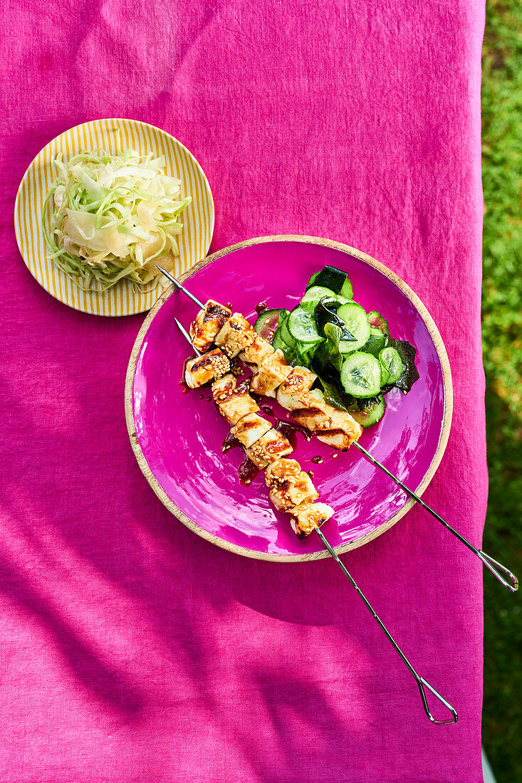 Grilled halloumi skewers with a cucumber and wakame salad, and a ginger and shredded cabbage salad