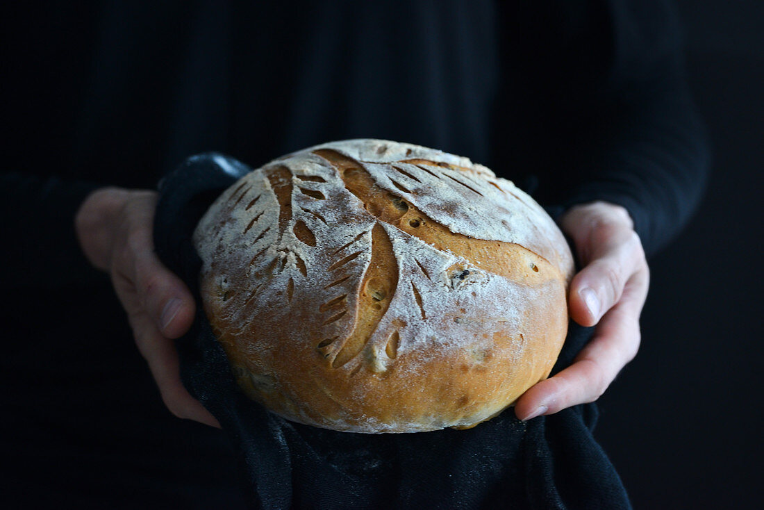 Hände halten einen Laib Brot