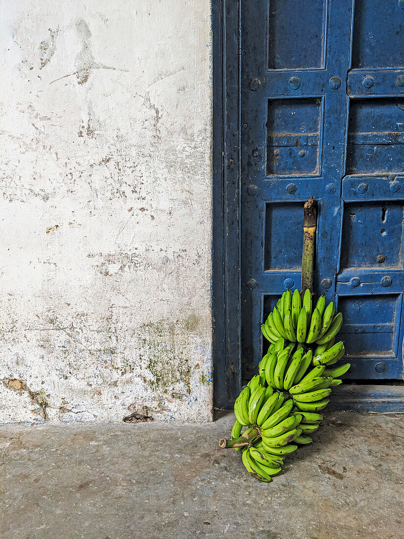 Grüne Bananen an einer alten Tür (Sansibar)