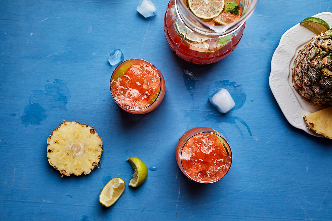 Ananas-Hibiskus-Cocktail in Krug und Gläsern