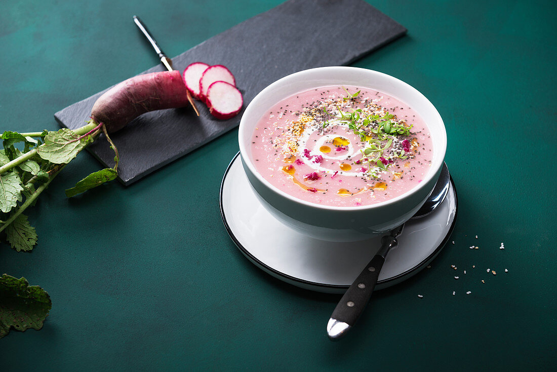 Vegan red radish cream soup with popped amaranth, chia seeds, cress and garlic oil