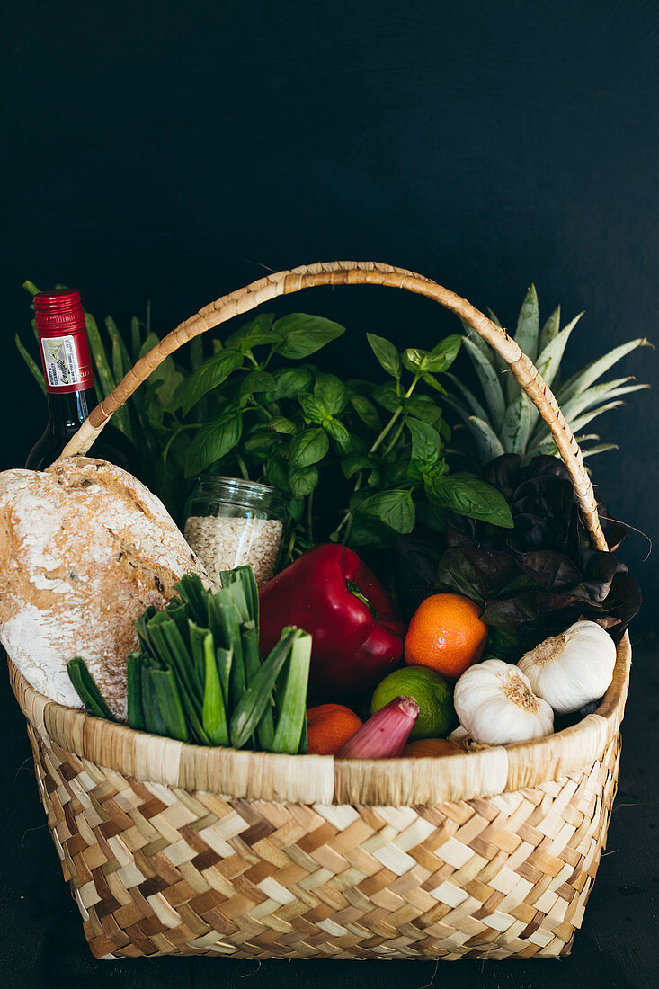 Korb mit Brot, Gemüse, Obst und Kräutern