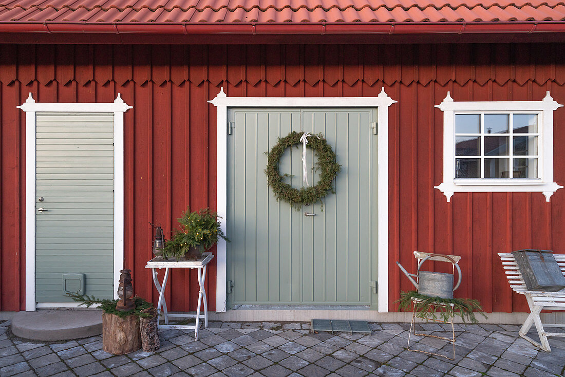 Christmas decorations outside Falu-red, Swedish house with paved courtyard