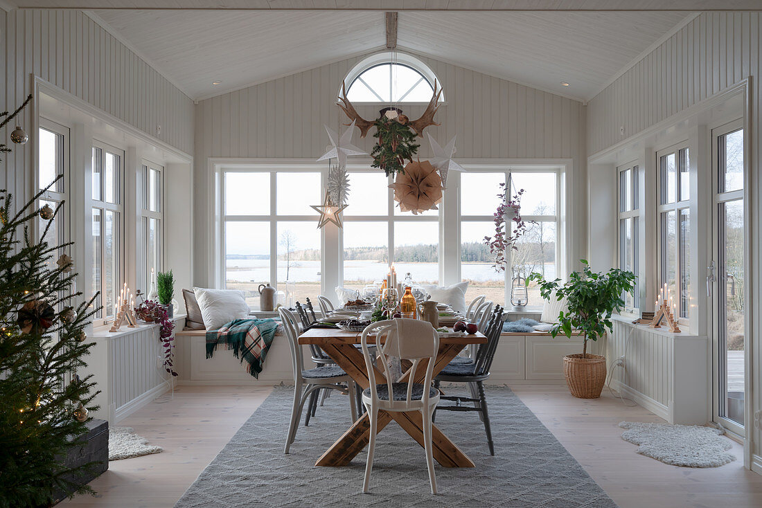 Set table in Scandinavian-style conservatory decorated for Christmas