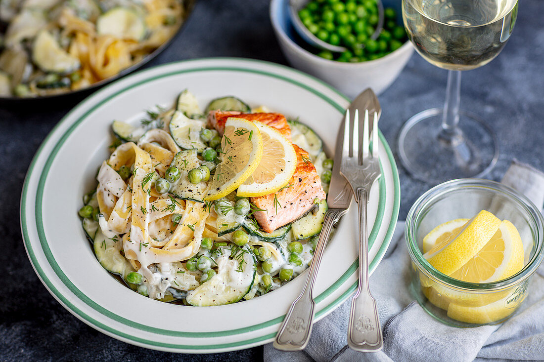 tagliatelle with courgette and green peas in creamy lemon sauce with fried salmon