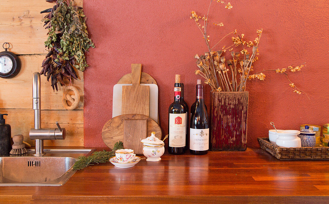 Chopping boards, wine and dried flowers in wooden vase