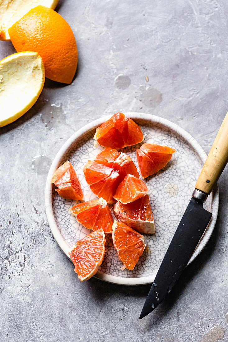 Slices of carra carra oranges on a ceramic plate.