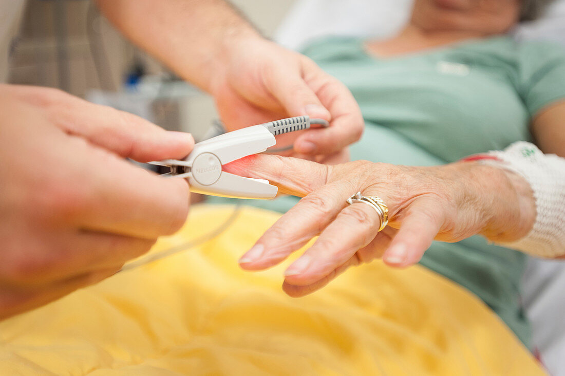 Nurse placing pulse oximeter on patient's finger