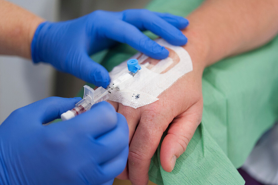 Nurse putting an IV cannula in a patient's hand