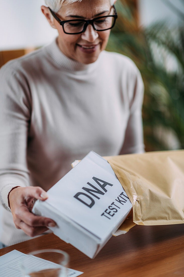 Senior woman preparing DNA test kit