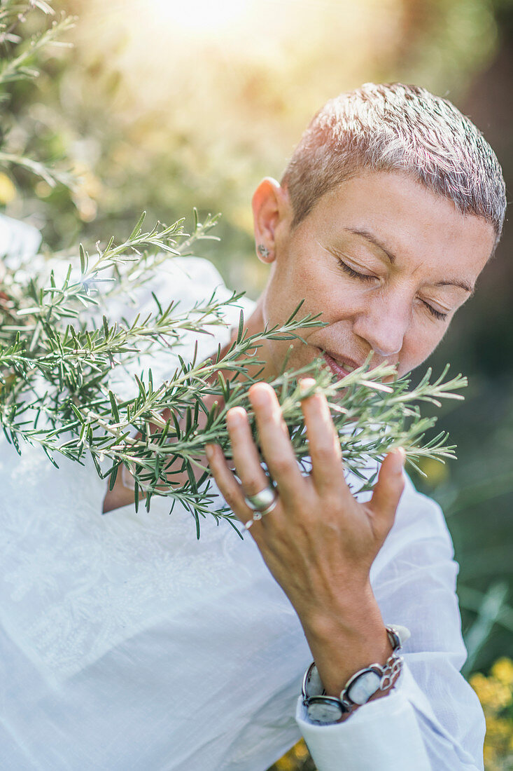 Woman enjoying the scent of rosemary