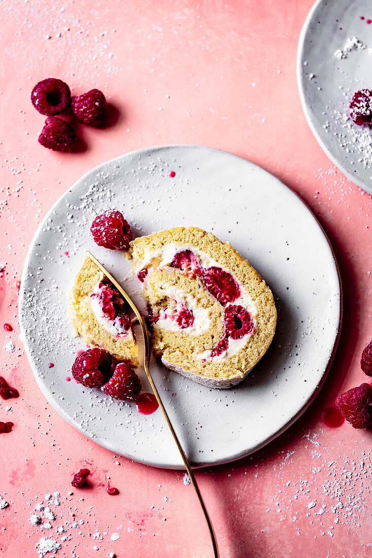 Slice of raspberry roll cake with fresh cream