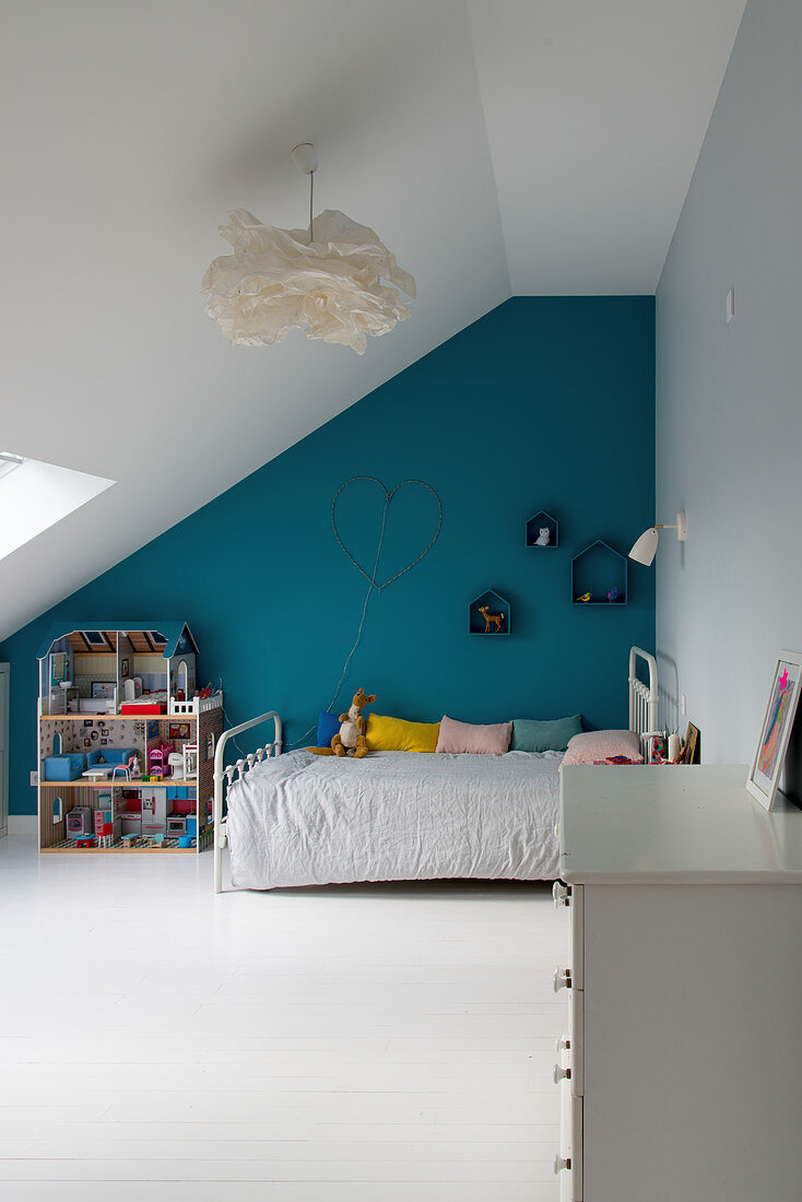 Child's attic bedroom with petrol-blue accent wall