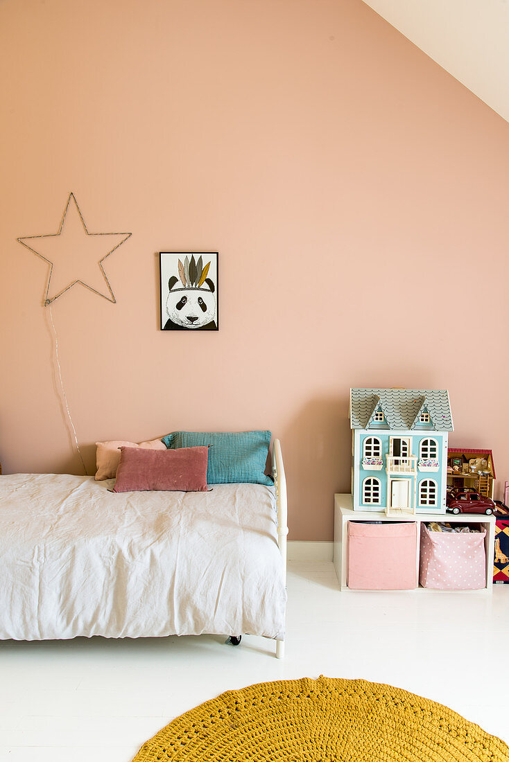 Child's attic bedroom with pink wall
