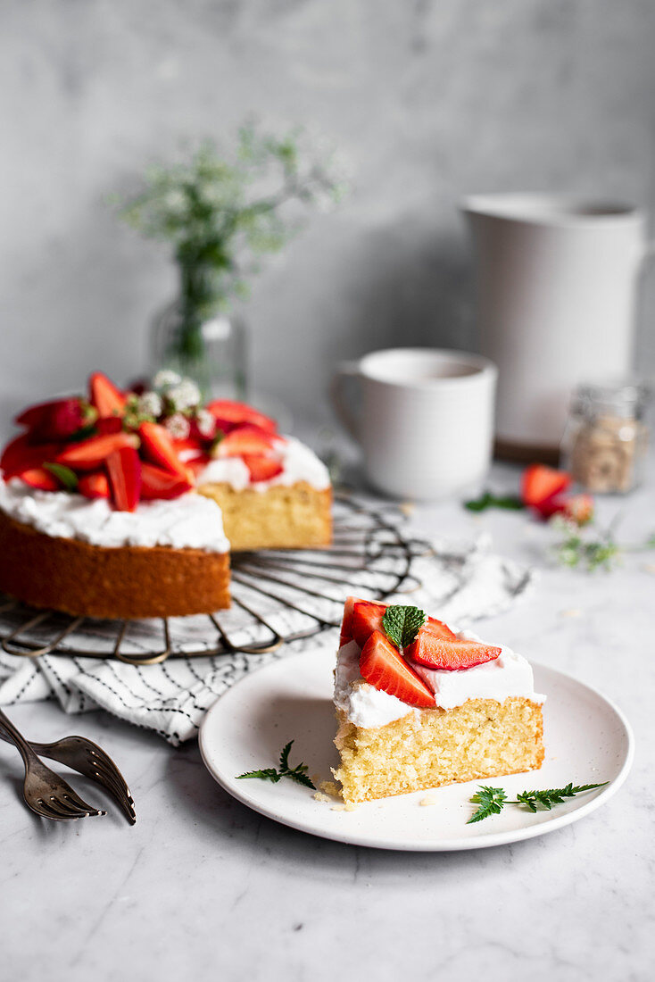 Biskuitkuchen mit Joghurtcreme und Erdbeeren, angeschnitten