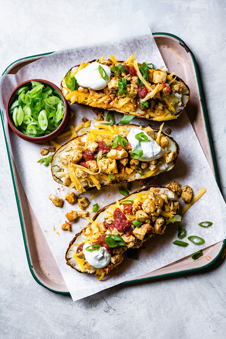 Tofu loaded baked potatoes with cheese, salsa, sour cream and scallions.