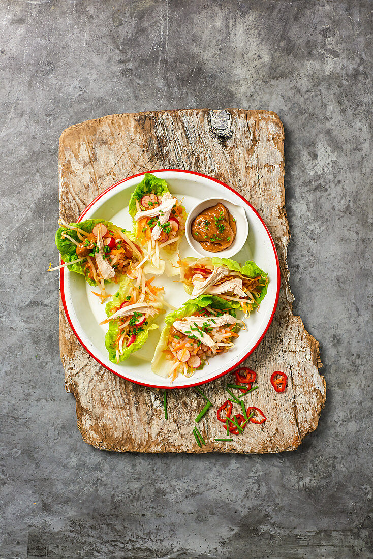 Hühnerfleisch mit Gemüse und Satesauce im Salatblatt