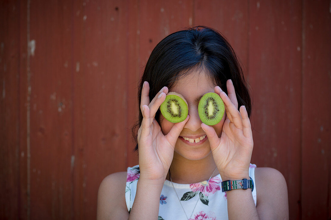 A girl holding kiwis