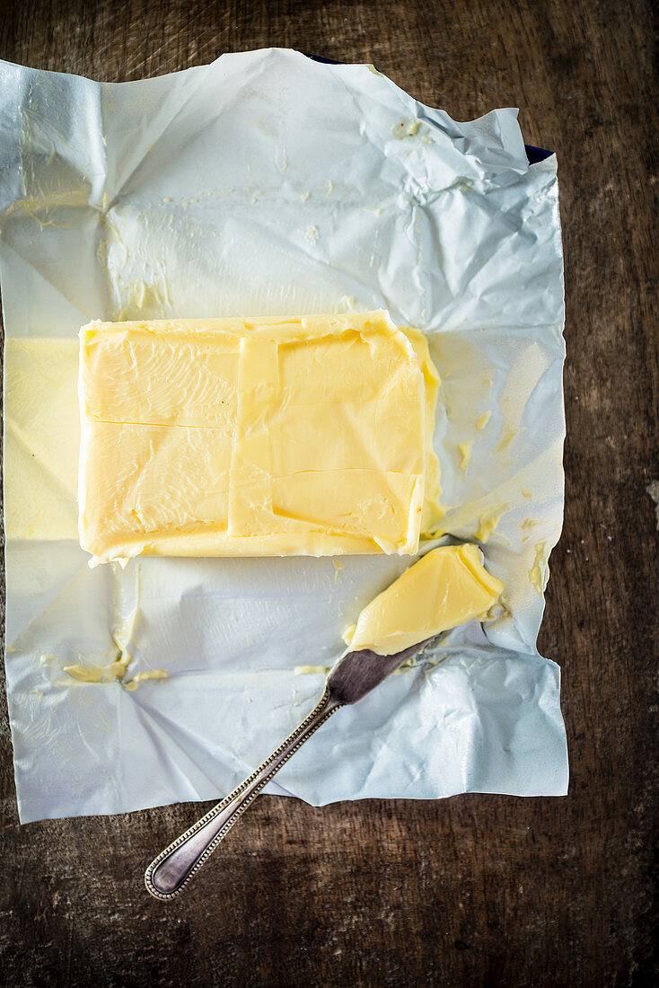 Butter mit Messer auf Butterpapier